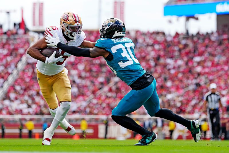 Sep 28, 2025; Santa Clara, California, USA; San Francisco 49ers wide receiver Jauan Jennings (15) runs the ball as Jacksonville Jaguars cornerback Montaric Brown (30) defends during the second half at Levi's Stadium. Mandatory Credit: Kyle Terada-Imagn Images