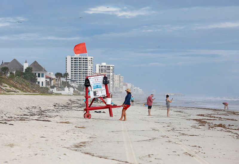 Beachgoers take pictures of the waves that Tropical Storm Imelda is bringing to Wilbur-By-the-Sea on Monday, Sept. 29, in Volusia County. Visitors and residents in Volusia and Flagler are urged to stay out of the water due to a risk of high rip currents expected through mid-week as Imelda travels east of Florida in the Atlantic, according to county officials and the National Weather Service.