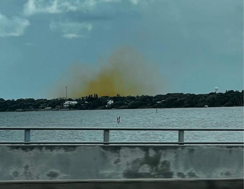 A plume of orange smoke rises from the site of FAR Research Center in Palm Bay.