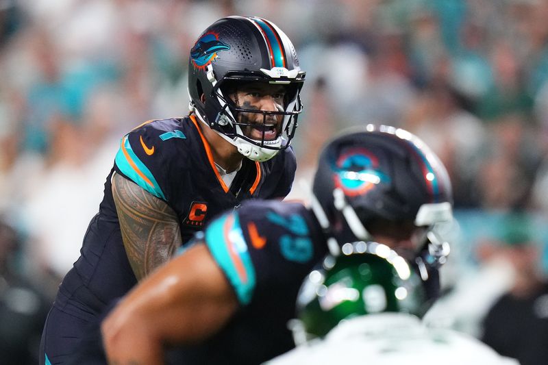 Sep 29, 2025; Miami Gardens, Florida, USA; Miami Dolphins quarterback Tua Tagovailoa (1) reacts against the New York Jets during the first half at Hard Rock Stadium. Mandatory Credit: Rich Storry-Imagn Images
