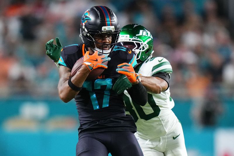 Sep 29, 2025; Miami Gardens, Florida, USA; Miami Dolphins wide receiver Jaylen Waddle (17) makes a catch against New York Jets cornerback Michael Carter II (30) during the first half at Hard Rock Stadium. Mandatory Credit: Rich Storry-Imagn Images
