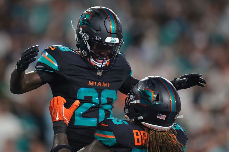 Sep 29, 2025; Miami Gardens, Florida, USA; Miami Dolphins running back De'von Achane (28) reacts after scoring a touchdown against the New York Jets during the second half at Hard Rock Stadium. Mandatory Credit: Sam Navarro-Imagn Images