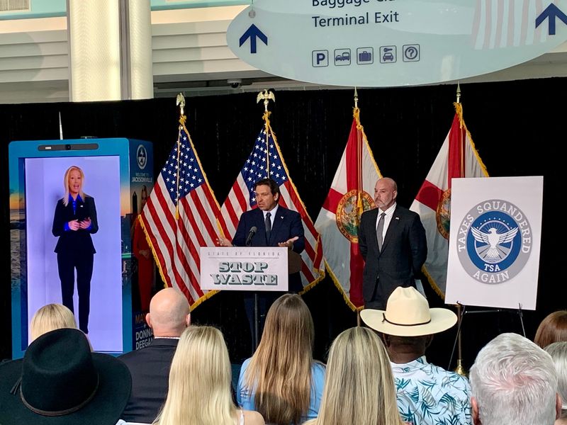 Florida Gov. Ron DeSantis speaks during an Oct. 1 appearance at Jacksonville International Airport where he and state Chief Financial Officer Blaise Ingoglia, at right, criticized the city of Jacksonville spending $75,000 on technology that plays hologram-like video of Mayor Donna Deegan greeting airport travelers.