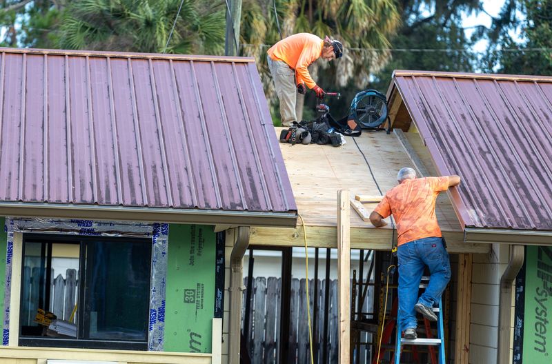 Workers work on the roof at the former Budget Inn on Southwest 13th Street on Oct. 2 in Gainesville as Alachua County continues renovating the space for affordable housing.