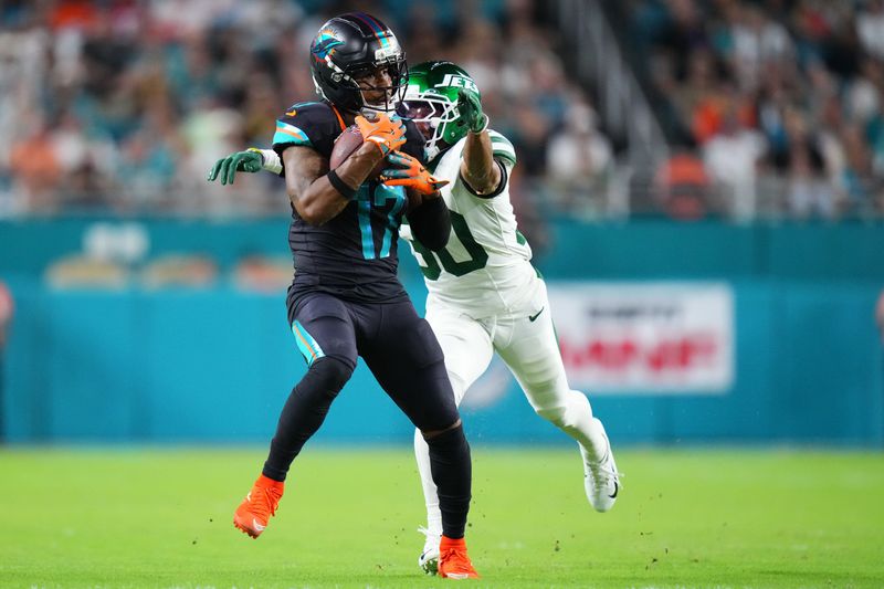Sep 29, 2025; Miami Gardens, Florida, USA; Miami Dolphins wide receiver Jaylen Waddle (17) makes a catch against New York Jets cornerback Michael Carter II (30) during the first half at Hard Rock Stadium. Mandatory Credit: Rich Storry-Imagn Images