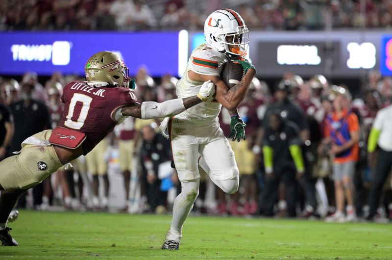 Oct 4, 2025; Tallahassee, Florida, USA; Miami Hurricanes wide receiver CJ Daniels (7) scores a touchdown against Florida State Seminoles defensive back Earl Little Jr. during the second half at Doak S. Campbell Stadium. Mandatory Credit: Melina Myers-Imagn Images