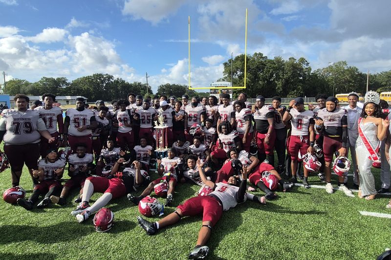 Raines players and coaches celebrate with the trophy after defeating Ribault 53-0 in the Northwest Classic high school football game on Oct. 4, 2025. [Clayton Freeman/Florida Times-Union]