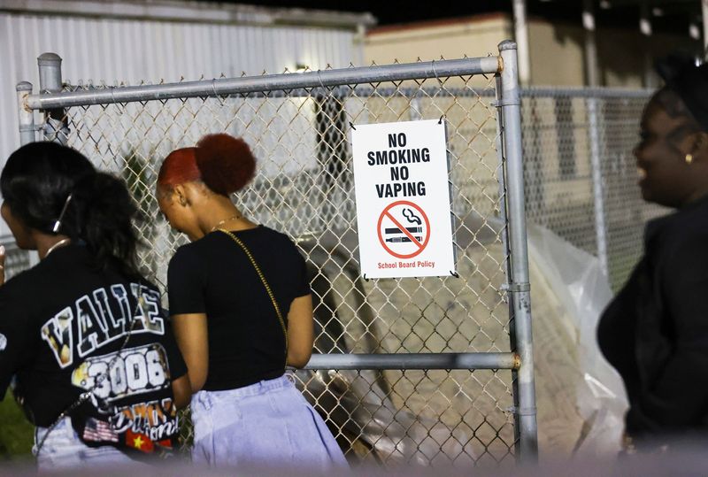 People walk by a "No Smoking, No Vaping" sign during a Friday night football game at Port St. Lucie High School Oct. 3, 2025.