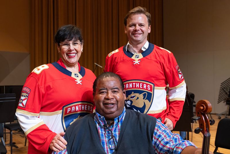 Palm Beach Symphony director of artistic operations Olga M. Vazquez (from left), symphony principal violinist Chauncey Patterson, and marketing and communications director Conor Price celebrate the Palm Beach-based nonprofit's new partnership with the Florida Panthers during the recording of an orchestral arrangement of the Panthers' goal song at the Frost School of Music at the University of Miami on Sept. 27.
