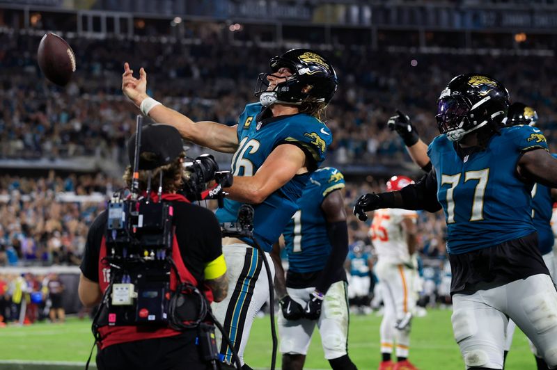 Jacksonville Jaguars quarterback Trevor Lawrence (16) flings the game-winning touchdown ball into the stands on his birthday as offensive tackle Anton Harrison (77) looks on during the fourth quarter of an NFL football matchup at EverBank Stadium, Monday, Oct. 6, 2025, in Jacksonville, Fla. The Jacksonville Jaguars edged the Kansas City Chiefs 31-28. [Corey Perrine/Florida Times-Union]