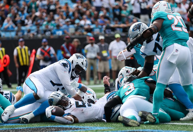 Oct 5, 2025; Charlotte, North Carolina, USA; Carolina Panthers running back Rico Dowdle (5) rolls in for a touchdown during the fourth quarter against the Miami Dolphins at Bank of America Stadium. Mandatory Credit: Cory Knowlton-Imagn Images