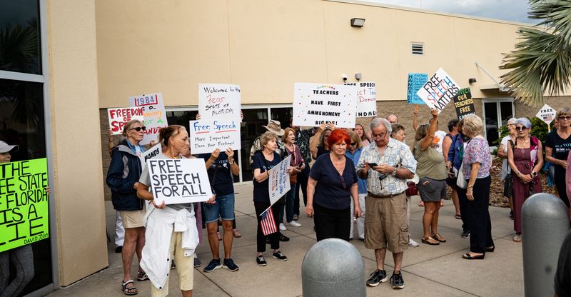 People hold a rally before a School Board meeting at the Lee County School District offices on Tuesday, Oct. 7, 2025. They were supporting Lee County teachers or employees who were put under investigation for making comments on social media regarding Charlie Kirk following his death.