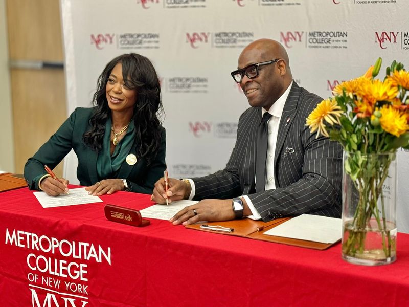 Florida A&M University President Marva Johnson and Metropolitan College of New York President Charles Gibbs sign documents as the institutions partner to create a graduate pathway program in supply chain management.