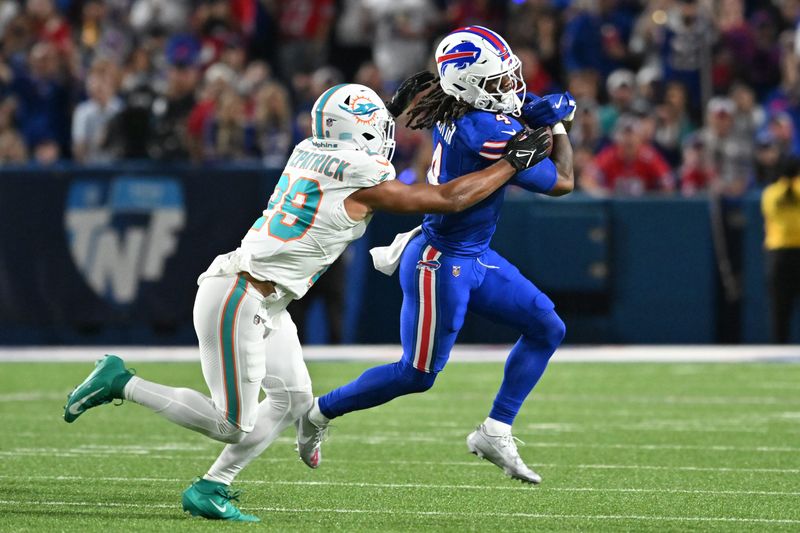 Sep 18, 2025; Orchard Park, New York, USA; Buffalo Bills running back James Cook (4) runs against Miami Dolphins free safety Minkah Fitzpatrick (29) in the first quarter at Highmark Stadium. Mandatory Credit: Mark Konezny-Imagn Images