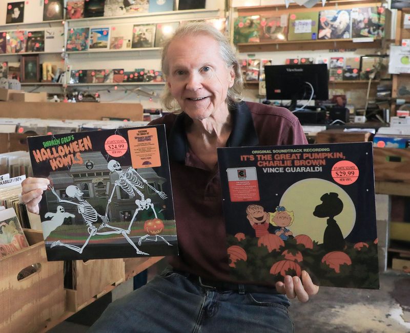 Mike Toole, owner of Atlantic Sounds record store in Daytona Beach, shows off a pair of Halloween records in the shop that has been a fixture for music lovers for 43 years. This week, the business will be expanding into a new space on the same block.