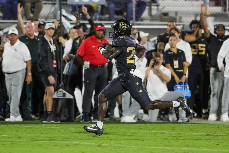 UCF Knights running back Myles Montgomery (22) runs the ball during the first quarter Oct. 4, 2025, against the Kansas Jayhawks at Acrisure Bounce House in Orlando, Florida. Mandatory Credit: Mike Watters-Imagn Images