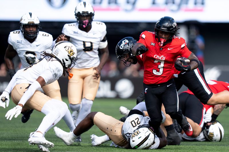 UCF Knights linebacker Lewis Carter (20) tackles Cincinnati Bearcats running back Tawee Walker (3) in the second quarter of the NCAA football game between the Cincinnati Bearcats and UCF Knights at Nippert Stadium in Cincinnati on Oct. 11, 2025.
