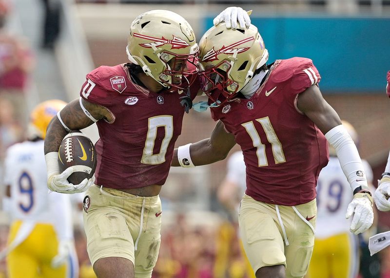 Oct 11, 2025; Tallahassee, Florida, USA; Florida State Seminoles safety Earl Little Jr. (0) and defensive back Ja'Bril Rawls (11) celebrate after an interception during the first half of the game against the Pittsburgh Panthers at Doak S. Campbell Stadium. Mandatory Credit: Melina Myers-Imagn Images