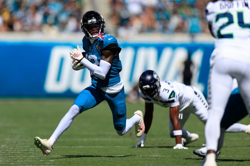 Jacksonville Jaguars wide receiver Travis Hunter (12) rushes for yards against Seattle Seahawks safety Nick Emmanwori (3) during the first quarter of an NFL football matchup, Sunday, Oct. 12, 2025, at EverBank Stadium in Jacksonville, Fla. [Corey Perrine/Florida Times-Union]