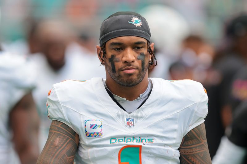 Oct 12, 2025; Miami Gardens, Florida, USA; Miami Dolphins quarterback Tua Tagovailoa (1) walks by the bench area against the Los Angeles Chargers during the fourth quarter at Hard Rock Stadium. Mandatory Credit: Sam Navarro-Imagn Images