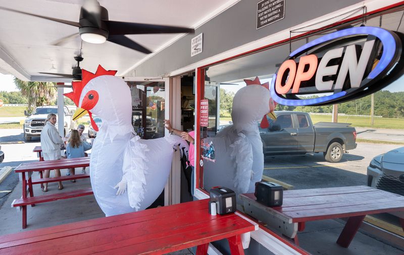General manager Charity Johnson goes outside in a chicken costume to wave to passers-by at Grover’s restaurant on David Highway in Pensacola on Oct. 14, 2025. This location just reopened after undergoing renovations.