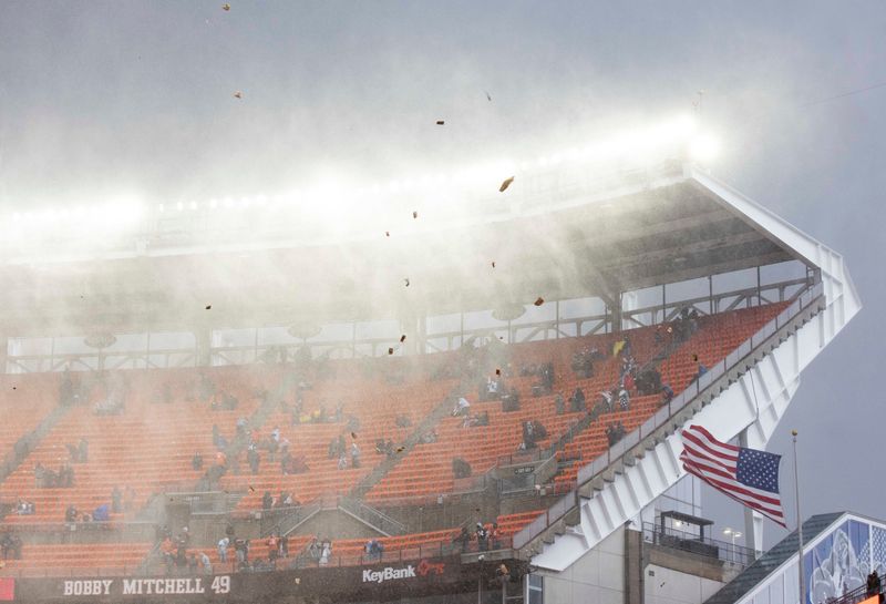 Nov 15, 2020; Cleveland, Ohio, USA; Debris flies through the air as rain and hail falls during the national anthem before the game between the Cleveland Browns and Houston Texans at FirstEnergy Stadium. The game has been delayed due to lightning. Mandatory Credit: Scott Galvin-USA TODAY Sports