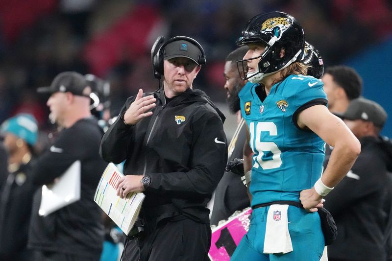 Oct 19, 2025; London, United Kingdom; Jacksonville Jaguars head coach Liam Coen talks with quarterback Trevor Lawrence (16) on the sidelines during the second half of an NFL International Series game at Wembley Stadium. Mandatory Credit: Kirby Lee-Imagn Images
