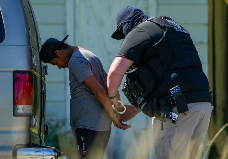 Two Florida Highway Patrol vehicles pull over a Ford E-350 van with a Georgia license plate off Orange Avenue and Vista Court, Oct. 21, 2025, at about 1 p.m., in Fort Pierce. Three unmarked vehicles were also involved in the traffic stop where four landscapers, who lived seasonally in Fort Pierce, were arrested following the traffic stop. Troopers placed the four in handcuffs as a Florida Highway Patrol helicopter circled the scene for about 45 minutes.