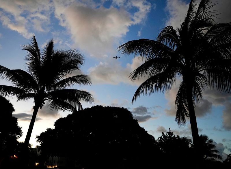 A plane flies over Lake Drive Park as new temporary flight restrictions over President Donald Trump's Mar-a-Lago estate are in effect on Oct. 22, 2025, in Palm Beach.