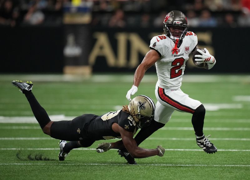 Oct 26, 2025; New Orleans, Louisiana, USA; Tampa Bay Buccaneers wide receiver Emeka Egbuka (2) runs for a gain past New Orleans Saints cornerback Quincy Riley (29) during the third quarter at Caesars Superdome. Mandatory Credit: Matthew Hinton-Imagn Images