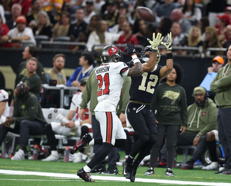 Oct 26, 2025; New Orleans, Louisiana, USA; New Orleans Saints wide receiver Chris Olave (12) catches a pass under pressure from Tampa Bay Buccaneers cornerback Benjamin Morrison (21) during the fourth quarter at Caesars Superdome. Mandatory Credit: Stephen Lew-Imagn Images