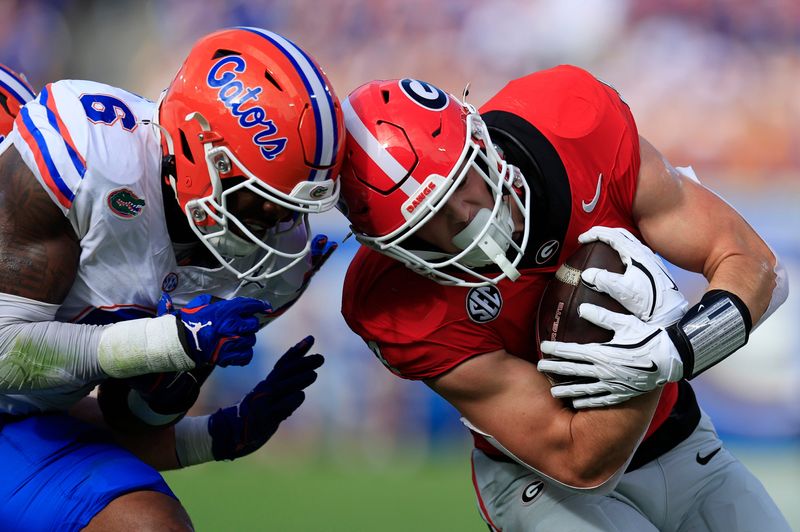 Florida Gators linebacker Shemar James (6) tackles Georgia Bulldogs tight end Oscar Delp (4) during the first quarter of an NCAA college football matchup Saturday, Nov. 2, 2024 at EverBank Stadium in Jacksonville, Fla. The Bulldogs defeated the Gators 34-20.