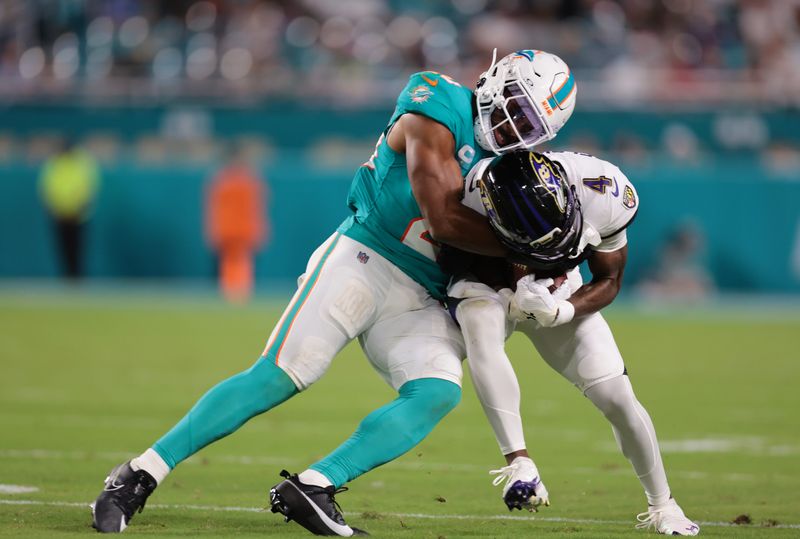 Oct 30, 2025; Miami Gardens, Florida, USA; Miami Dolphins linebacker Jordyn Brooks (20) tackles Baltimore Ravens wide receiver Zay Flowers (4) during the third quarter at Hard Rock Stadium. Mandatory Credit: Sam Navarro-Imagn Images