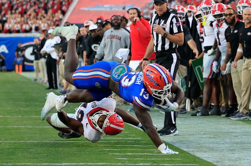 Florida Gators running back Jadan Baugh (13) is tackled by Georgia Bulldogs linebacker Justin Williams (19) during the third quarter of an NCAA football game, Saturday, Nov. 1, 2025, at EverBank Stadium in Jacksonville, Fla. Georgia held off Florida 24-20. [Corey Perrine/Florida Times-Union]