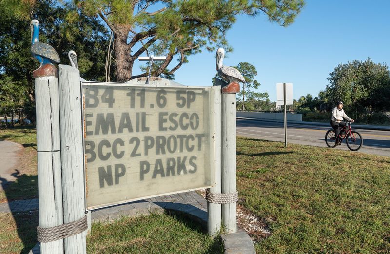 A person rides a bike past the sign at Navy Point Park in Warrington on Nov. 3, 2025.