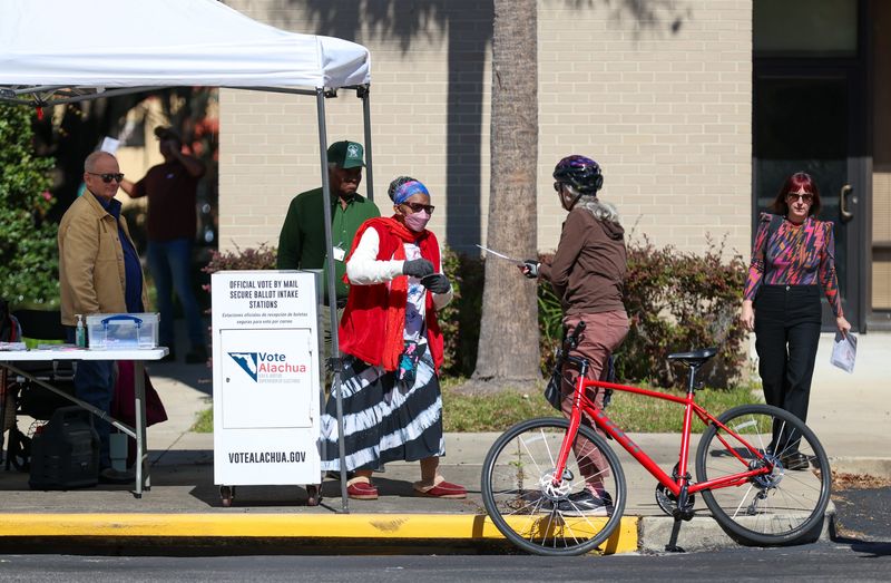 Poll workers Tim Hoskinson, left, and Carolyn Eason, right, take in a steady stream of mail-in ballots for the special election on control of Gainesville Regional Utilities, on Nov. 4 at the Supervisor of Elections Office in Gainesville.