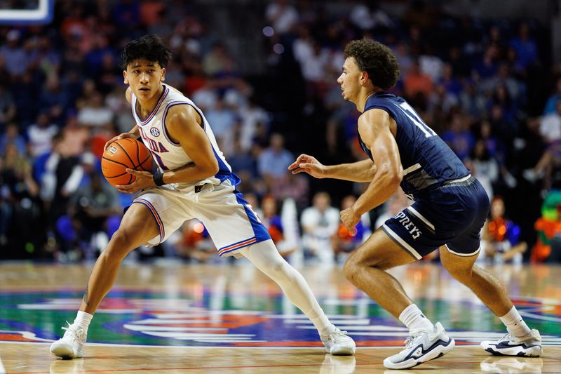 Nov 6, 2025; Gainesville, Florida, USA; Florida Gators guard Xaivian Lee (1) looks to pass while North Florida Ospreys guard Kamrin Oriol (11) defends during the second half at Exactech Arena at the Stephen C. O'Connell Center. Mandatory Credit: Matt Pendleton-Imagn Images