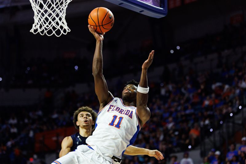 Nov 6, 2025; Gainesville, Florida, USA; Florida Gators guard CJ Ingram II (11) shoots over North Florida Ospreys guard Kamrin Oriol (11) during the second half at Exactech Arena at the Stephen C. O'Connell Center. Mandatory Credit: Matt Pendleton-Imagn Images