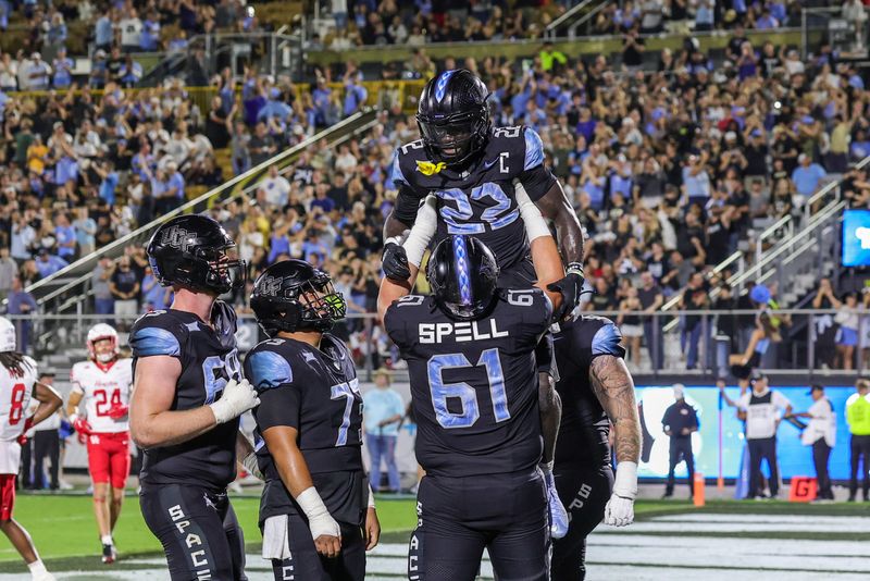 Nov 7, 2025; Orlando, Florida, USA; UCF Knights running back Myles Montgomery (22) is lifted into the air by offensive lineman Owen Spell (61) after scoring during the second quarter at Acrisure Bounce House. Mandatory Credit: Mike Watters-Imagn Images