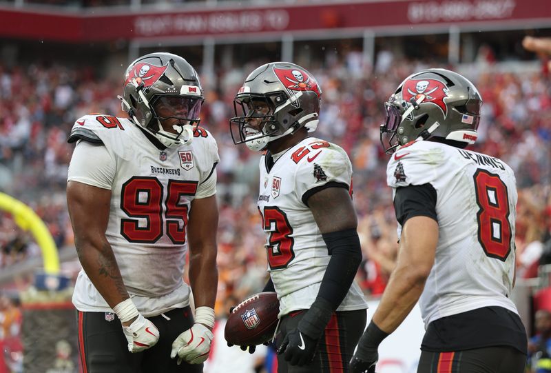 Nov 9, 2025; Tampa, Florida, USA; Tampa Bay Buccaneers defensive end Elijah Roberts (95), safety Tykee Smith (23) and linebacker Sirvocea Dennis (8) celebrate an interception during the fourth quarter against the New England Patriots at Raymond James Stadium. Mandatory Credit: Nathan Ray Seebeck-Imagn Images