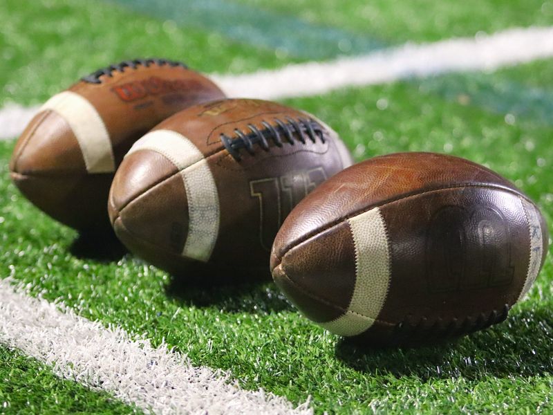 Three footballs lay on the sideline during halftime of an MIAA Division 2 Round of 16 football game between Bridgewater-Raynham and Woburn in Bridgewater, MA on Nov. 7, 2025.
