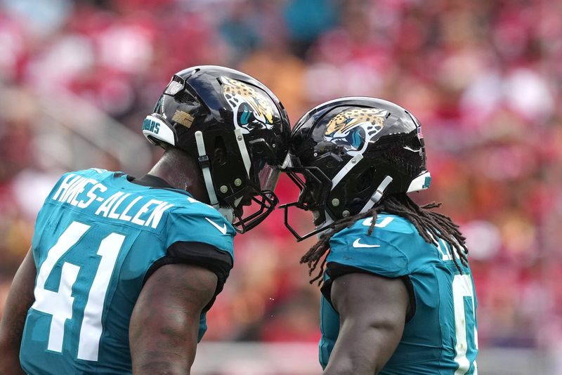 Sep 28, 2025; Santa Clara, California, USA; Jacksonville Jaguars linebacker Devin Lloyd (right) celebrates with defensive end Josh Hines-Allen (41) after intercepting a pass against the San Francisco 49ers during the second quarter at Levi's Stadium. Mandatory Credit: Darren Yamashita-Imagn Images