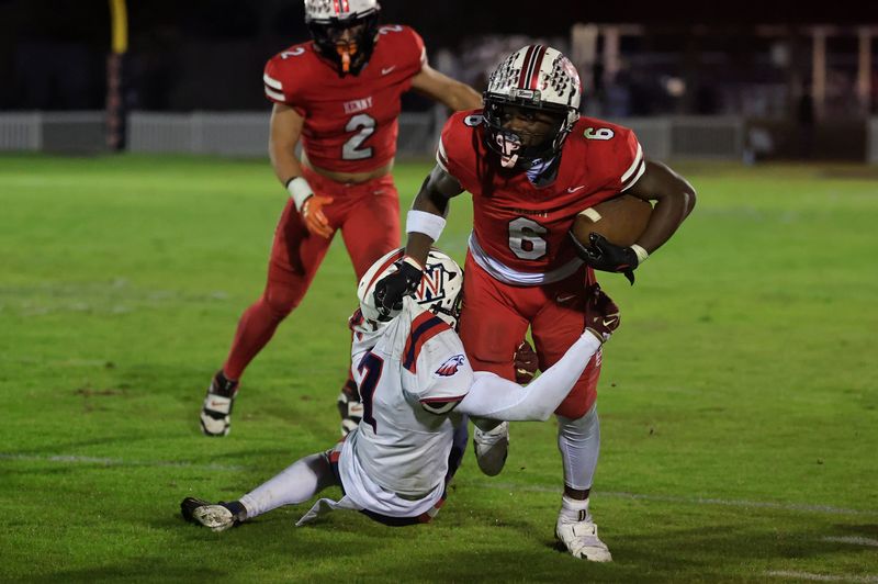 Bishop Kenny's Caleb Mattison (6) rushes for yards against Wakulla's Auvion Thomas (7) during the third quarter of a high school football playoff.