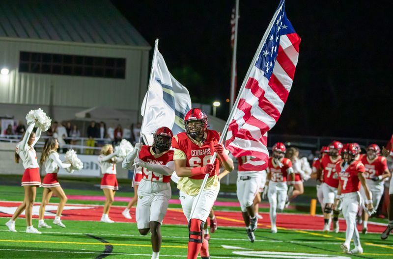 Cardinal Mooney won its Class 2A-Region 3 quarterfinal over North Broward Prep 55-7 on Friday, Nov. 14, 2025. Jackson Snelling (68) leads Cardinal Mooney onto the field.