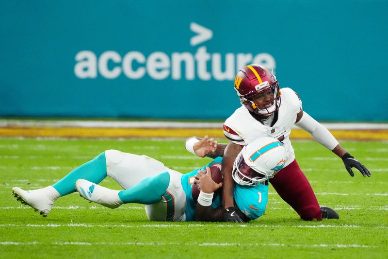 Nov 16, 2025; Madrid, Spain; Washington Commanders cornerback Jonathan Jones (31) sacks Miami Dolphins quarterback Tua Tagovailoa (1) in the second quarter during the 2025 NFL Madrid Game at Santiago Bernabeu Stadium. Mandatory Credit: Kirby Lee-Imagn Images