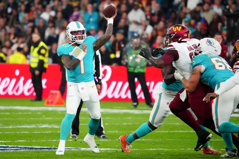 Nov 16, 2025; Madrid, Spain; Miami Dolphins quarterback Tua Tagovailoa (1) passes the ball against the Washington Commanders in the second quarter during the 2025 NFL Madrid Game at Santiago Bernabeu Stadium. Mandatory Credit: Kirby Lee-Imagn Images