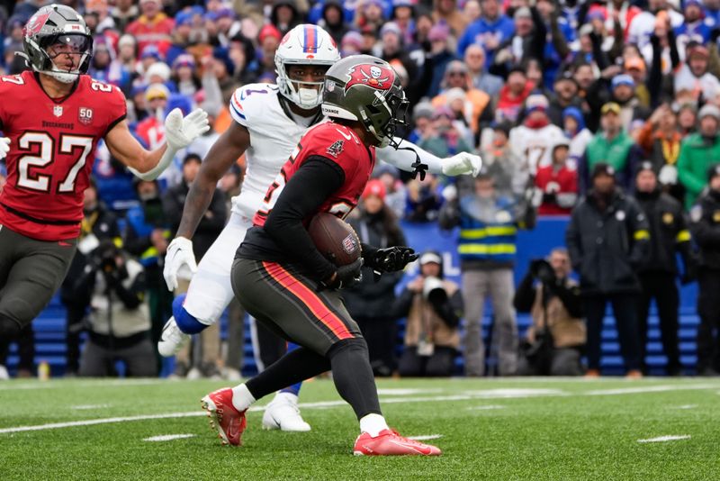 Nov 16, 2025; Orchard Park, New York, USA; Tampa Bay Buccaneers cornerback Jacob Parrish (25) runs the ball after an interception against the Buffalo Bills during the first quarter of the game at Highmark Stadium. Mandatory Credit: Gregory Fisher-Imagn Images