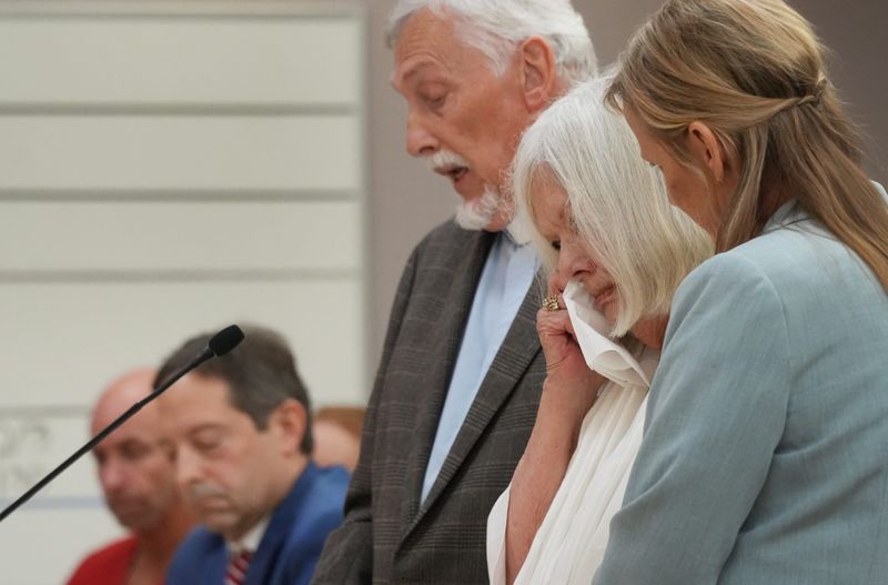 Lucinda Wallen, with victim advocate Lisa Mousseau at her side, wipes tears away as retired priest John Bender reads her statement to the court during the sentencing hearing for Matthew Inklebarger, seen in background at far left. Inklebarger was sentenced to 50 years for the murder of 75-year-old James Wallen during a 2020 burglary.