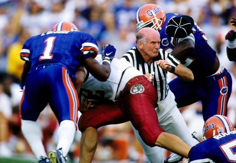 Nov 22, 1997; Gainesville, FL, USA; FILE PHOTO; Florida Gators linebacker Tony George (1) and Reggie McGrew (92) tackle Florida State Seminoles quarterback Thad Busby (12) as an official is caught in the middle of the play at Ben Hill Griffin Stadium. Mandatory Credit: RVR Photos-USA TODAY Sports