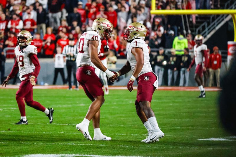 Nov 21, 2025; Raleigh, North Carolina, USA; Florida State Seminoles tight end Amaree Williams (40) and Florida State Seminoles linebacker Stefon Thompson (7) celebrate during the first half of the game against NC State Wolfpack at Carter-Finley Stadium. Mandatory Credit: Jaylynn Nash-Imagn Images